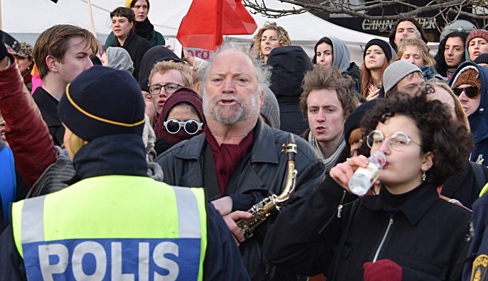 Dror Feiler försöker störa Folkets demonstration den 30 januari 2016 genom att spela på sin saxofon. Foto: Nya Tider